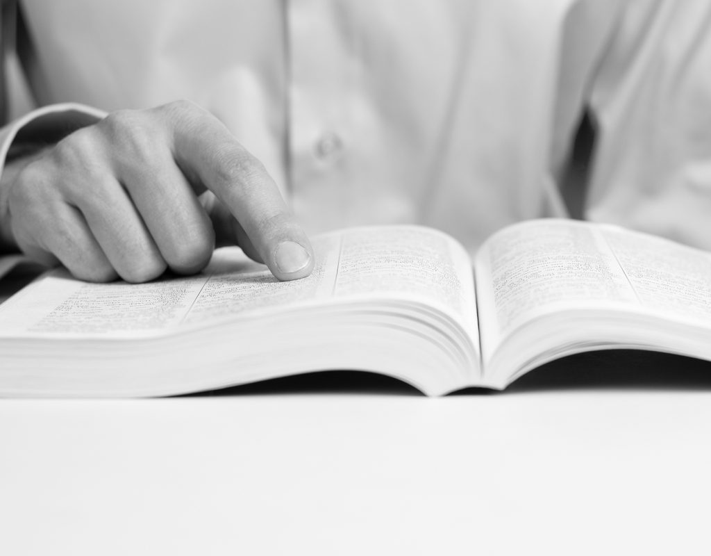 man reading a book, shows a close-up hand and a book